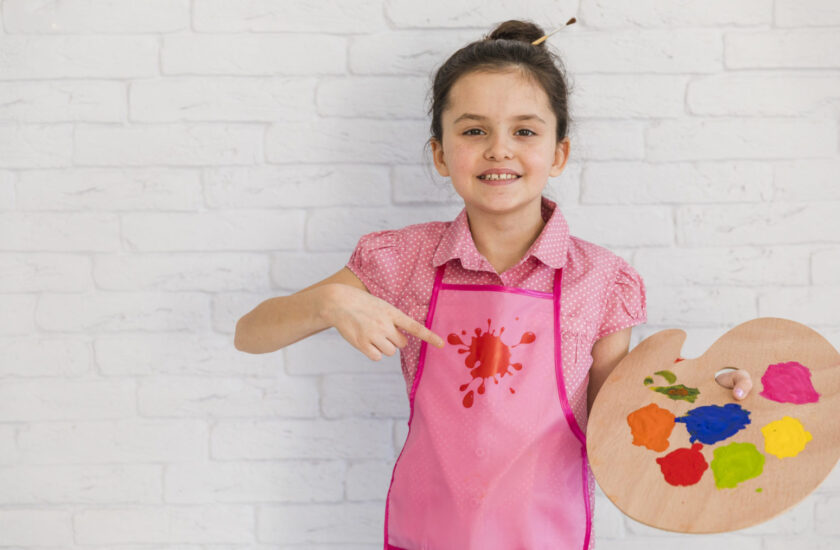 Uśmiechnięte dziecko trzymające paletę do malowania